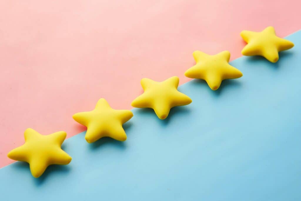 Five yellow stars to sell courses on Shopify, set against a pink and blue background.