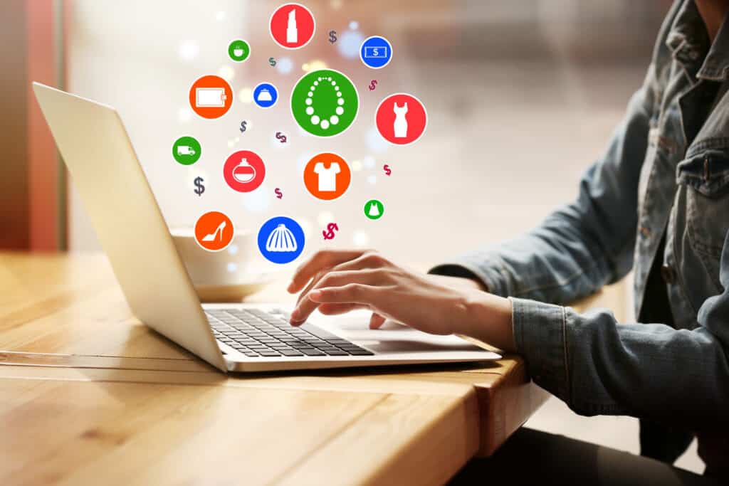 Person using laptop with icons representing various passive income businesses and digital activities floating above the screen.