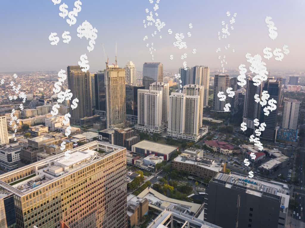 Aerial view of a cityscape with illustrated dollar signs superimposed to suggest financial prosperity or economic activity, highlighting areas ripe for passive income business opportunities.