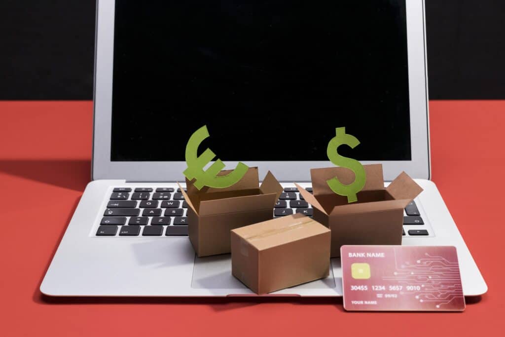 3D currency symbols emerging from cardboard boxes on a laptop keyboard, indicating e-commerce or online financial concepts related to passive income businesses to buy.