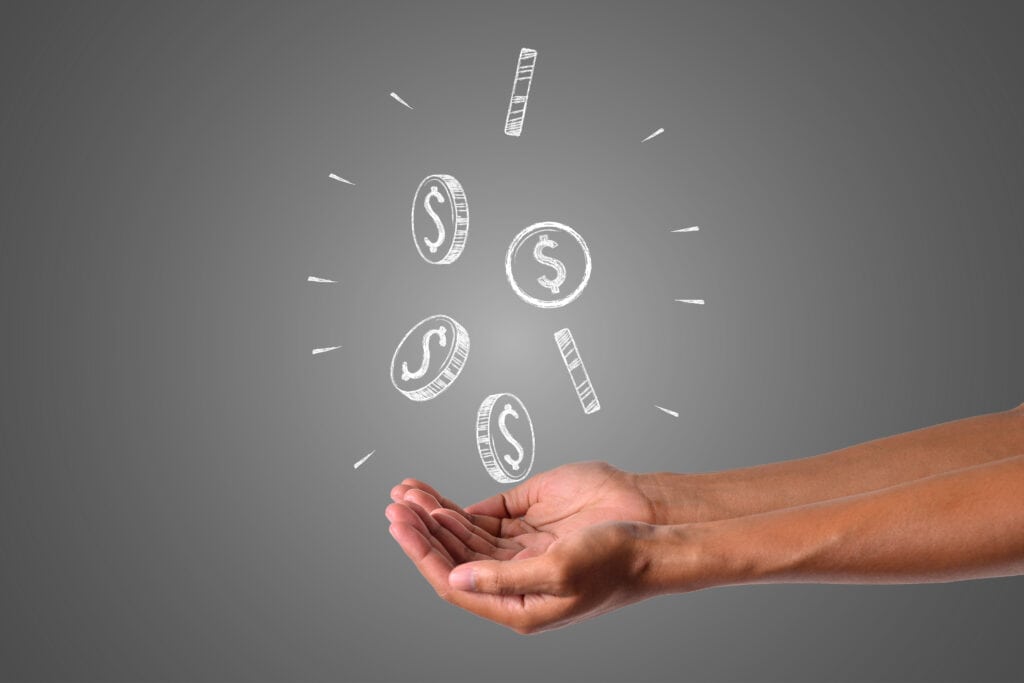 An open hand with illustrated coins and dollar signs seemingly floating above it, suggesting concepts of how to earn passive income online, earnings, or finance.